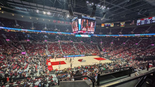Crowded basketball arena with packed stands and center court during a game.